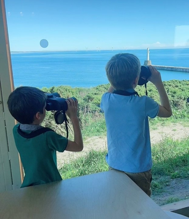 Two kids looking through binoculars.