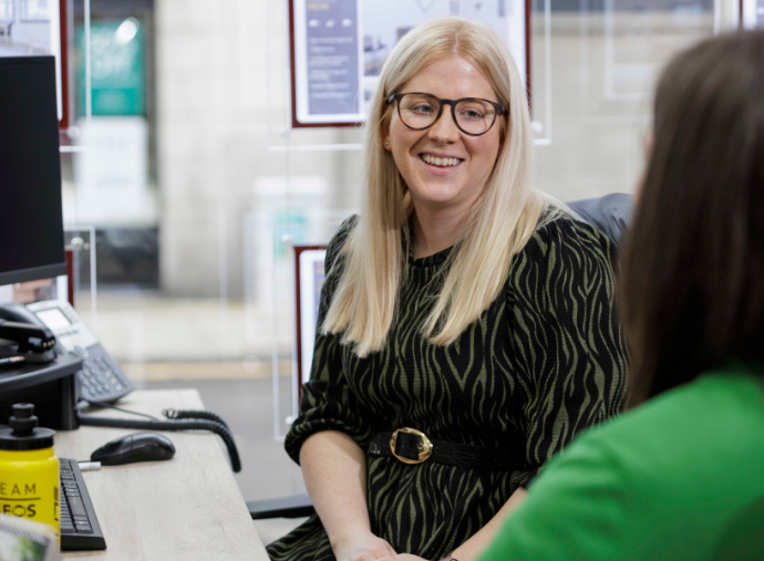 Two women talking in an office.