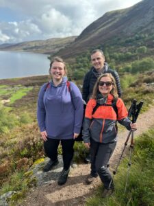 Three people on a path in the mountain.