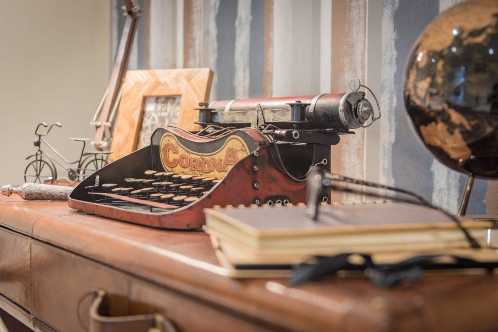 Antique typewriters and other subjects on a deck.