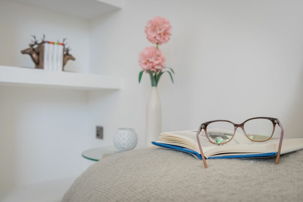 Open book and glasses on a cushion. 