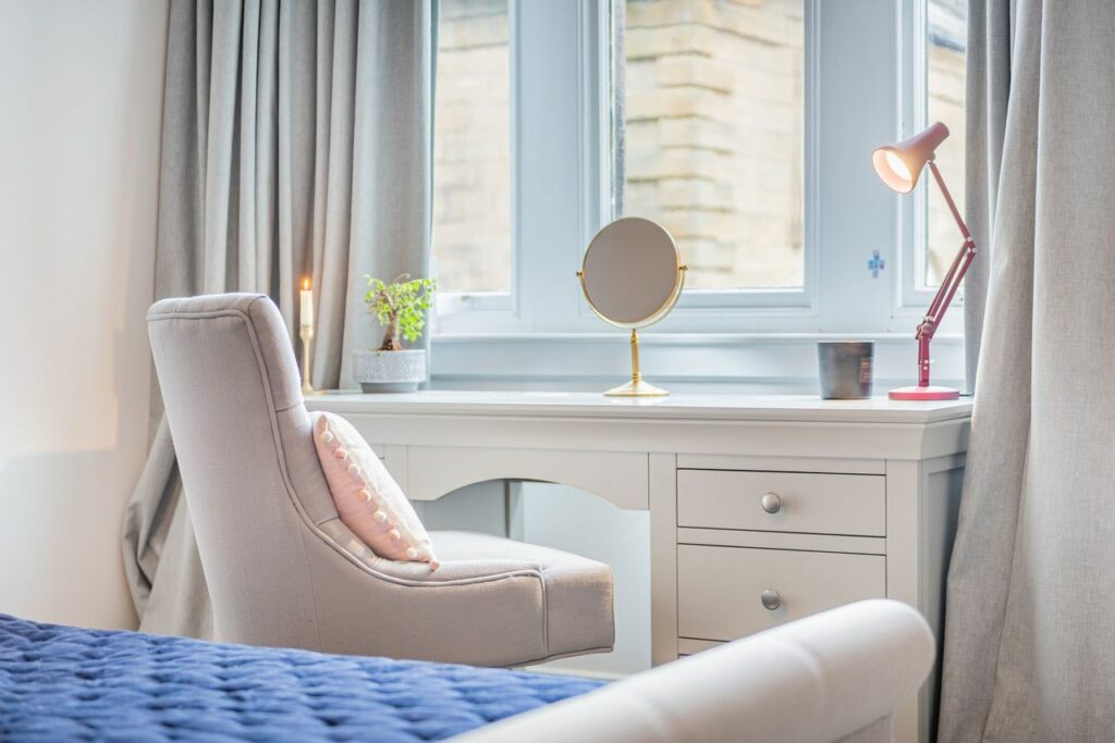 Beauty desk and chair in front of a window. 