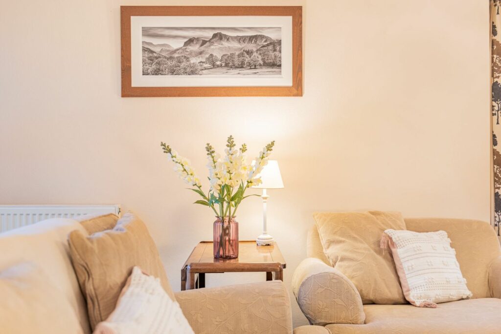 Living room corner with two sofas and flowers between them.