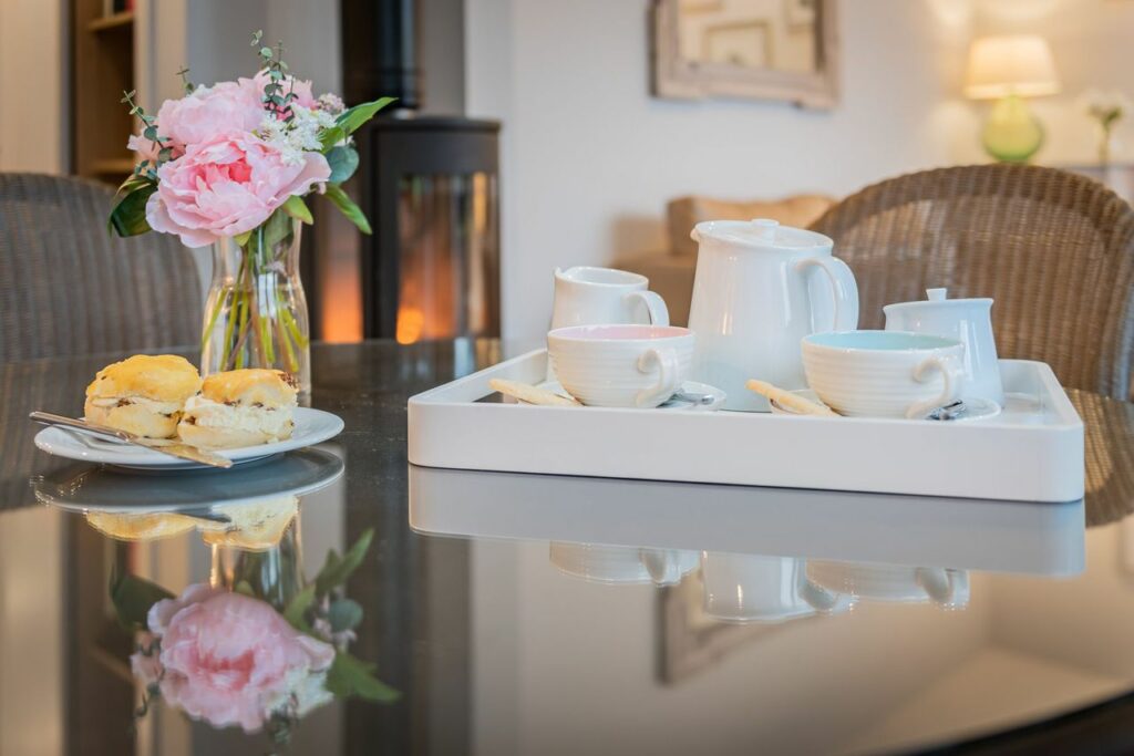 Porcelain tea set and desserts on a kitchen table. 