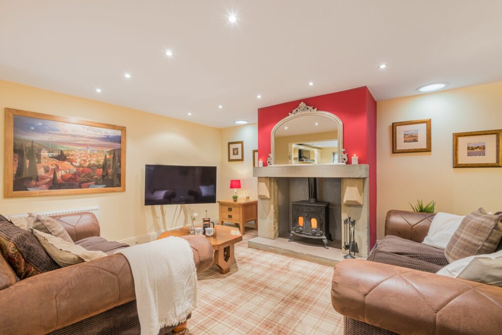 Living room with two big sofas, fireplace and a bigscreen TV.