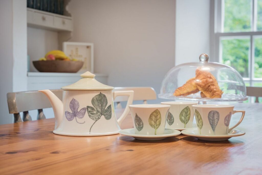 Tea set and croissants on a kitchen table. 