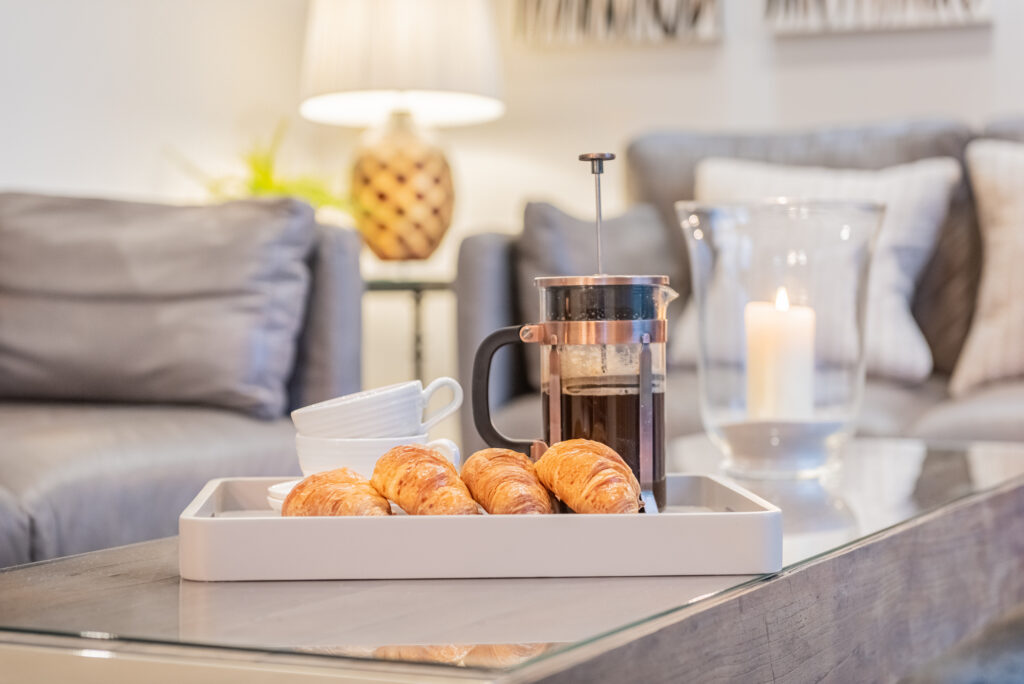 French Press, cups, and croissants on a coffee table
