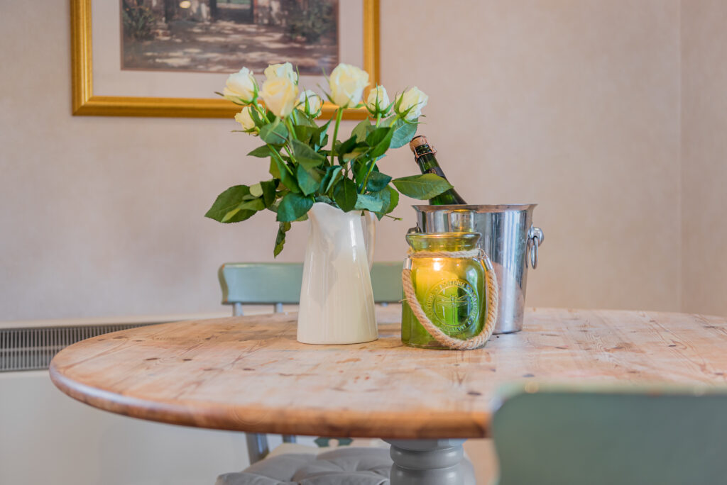 Small kitchen table, decorated with flowers and a candle.