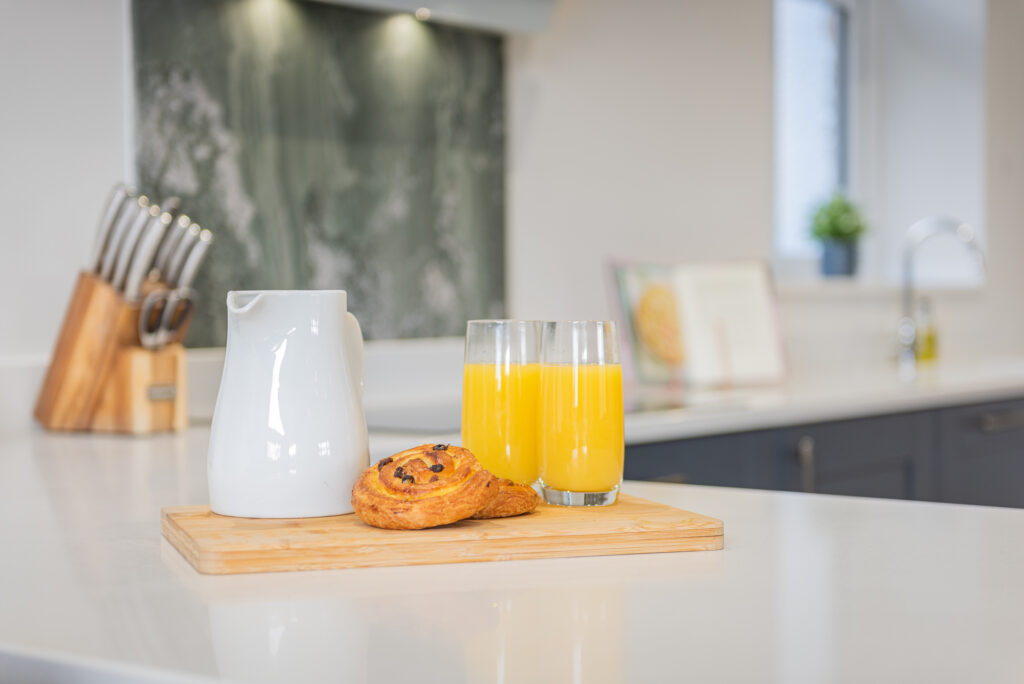 A table with breakfast on the kitchen countertop.
