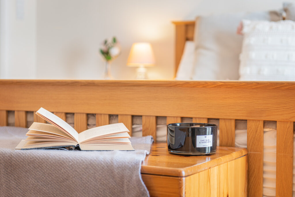 Close look of a book and a candle in a cozy bedroom.
