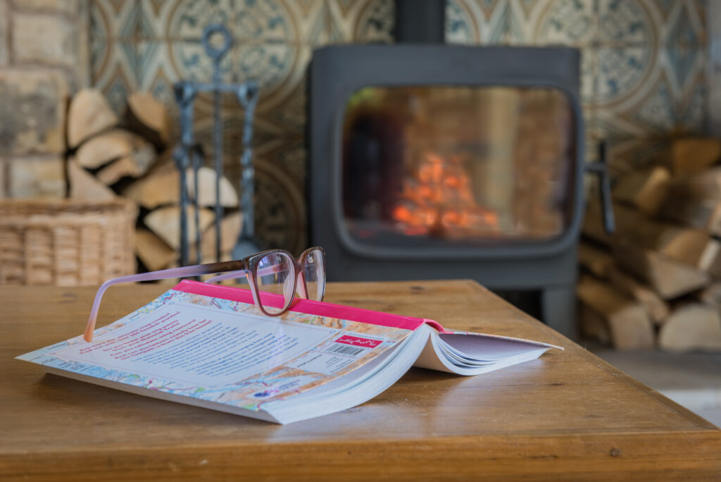 Book on a table in front of a fireplace 