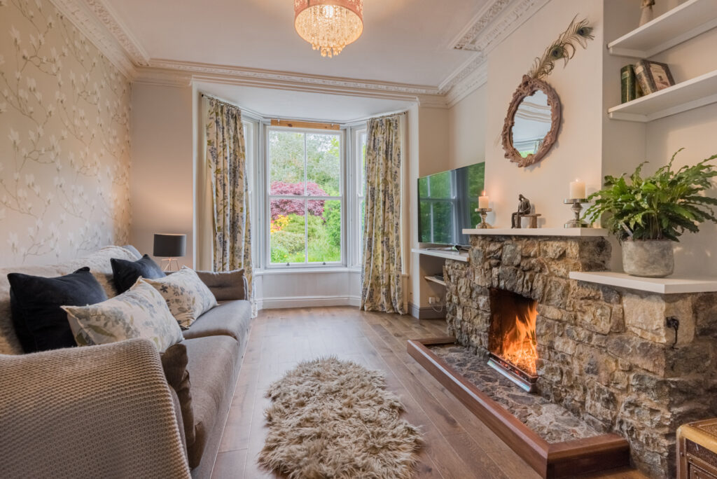 Cozy living room with big stone fireplace and fur rug on the floor 