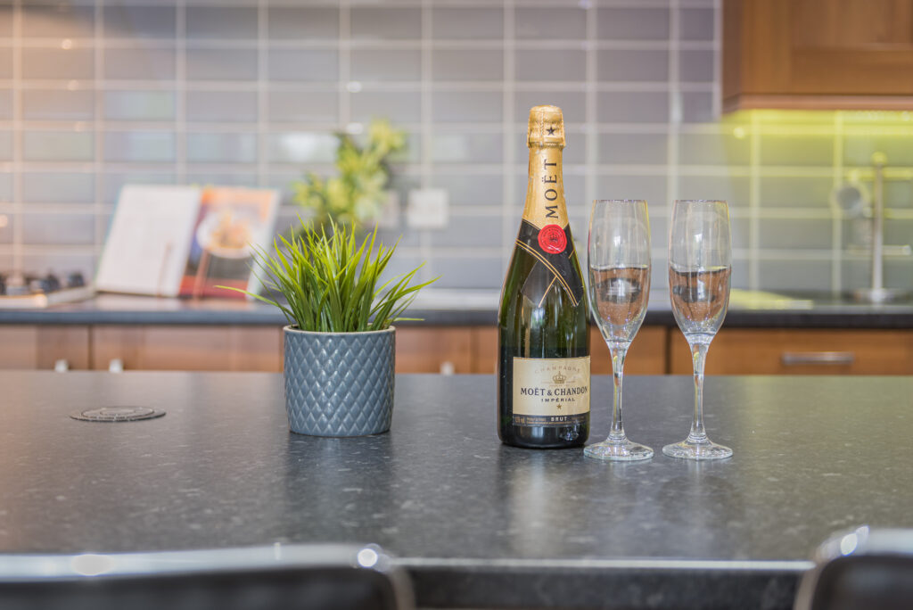 Kitchen countertop with champagne
and two glasses on it 