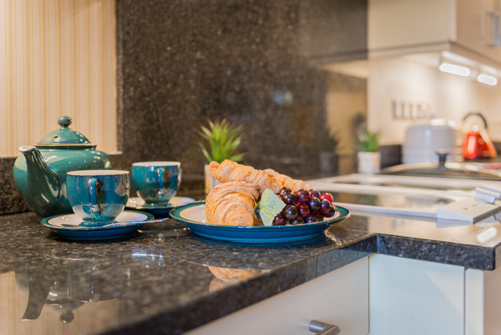 Plate with croissants and fruits on top of a countertop 