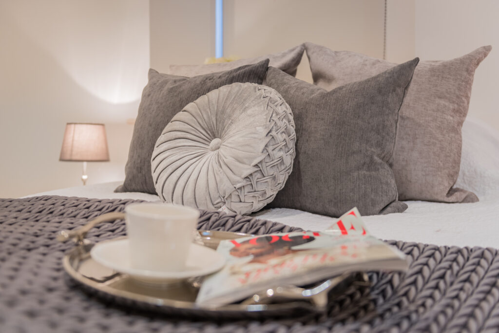 Bed with tray with cup and magazine on it