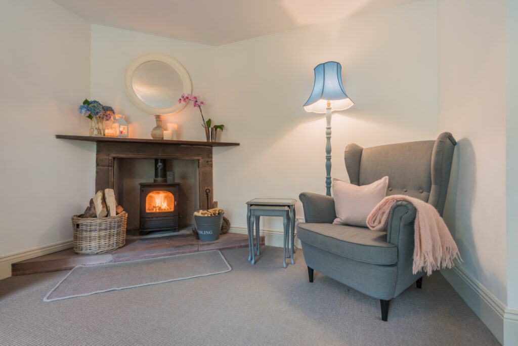 Cozy room corner with fireplace, and armchair. 