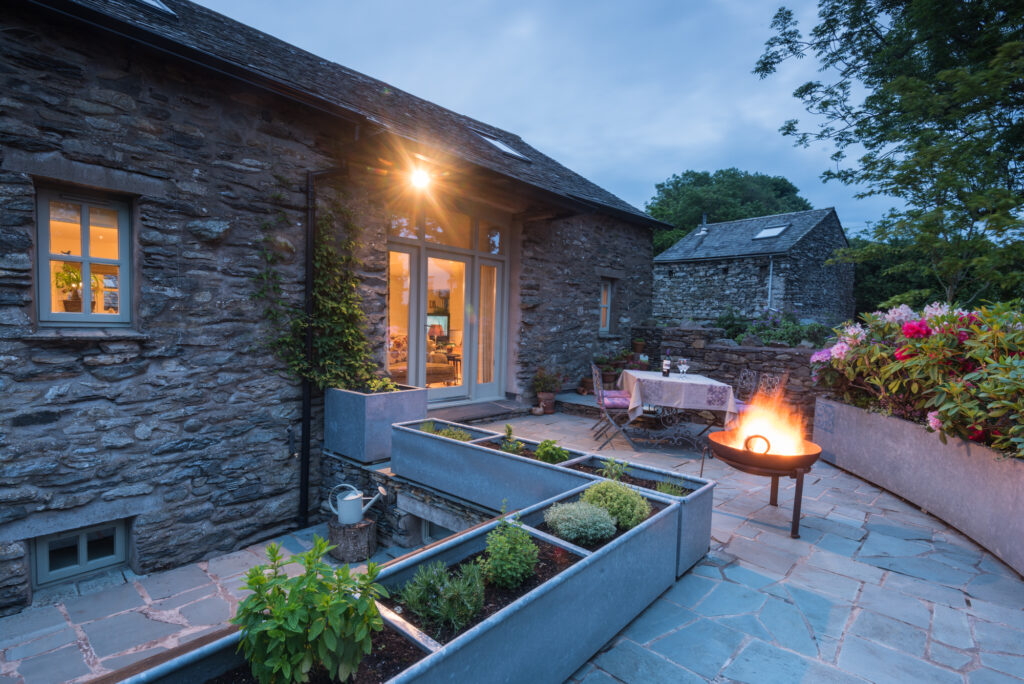 Patio with dining set, fireplace and flowers. 