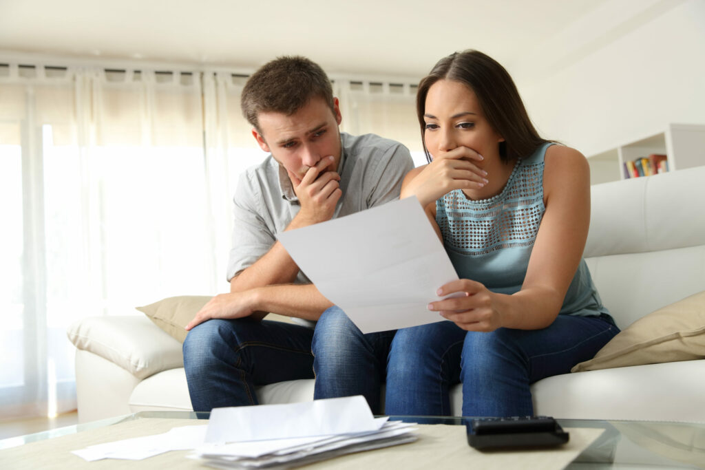 Sitting tenants reading a letter in a living room at home.