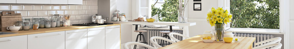 Bright kitchen with countertop and kitchen table with flowers. 