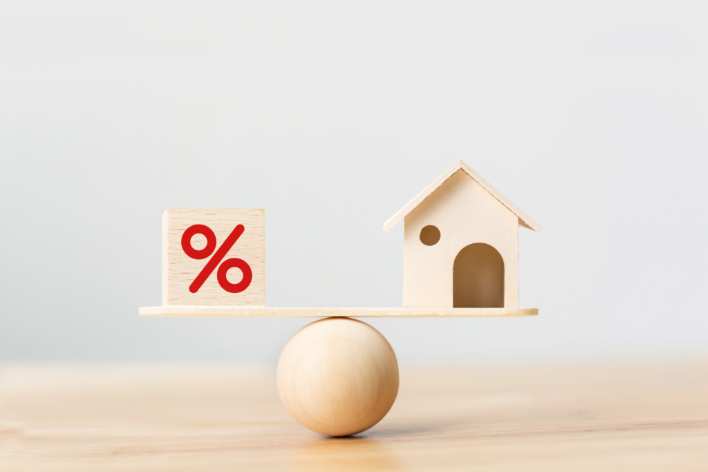 Scale with wooden house and percentage symbol.