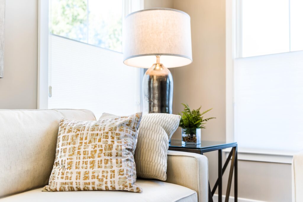 A sofa and lamp in a living room corner.