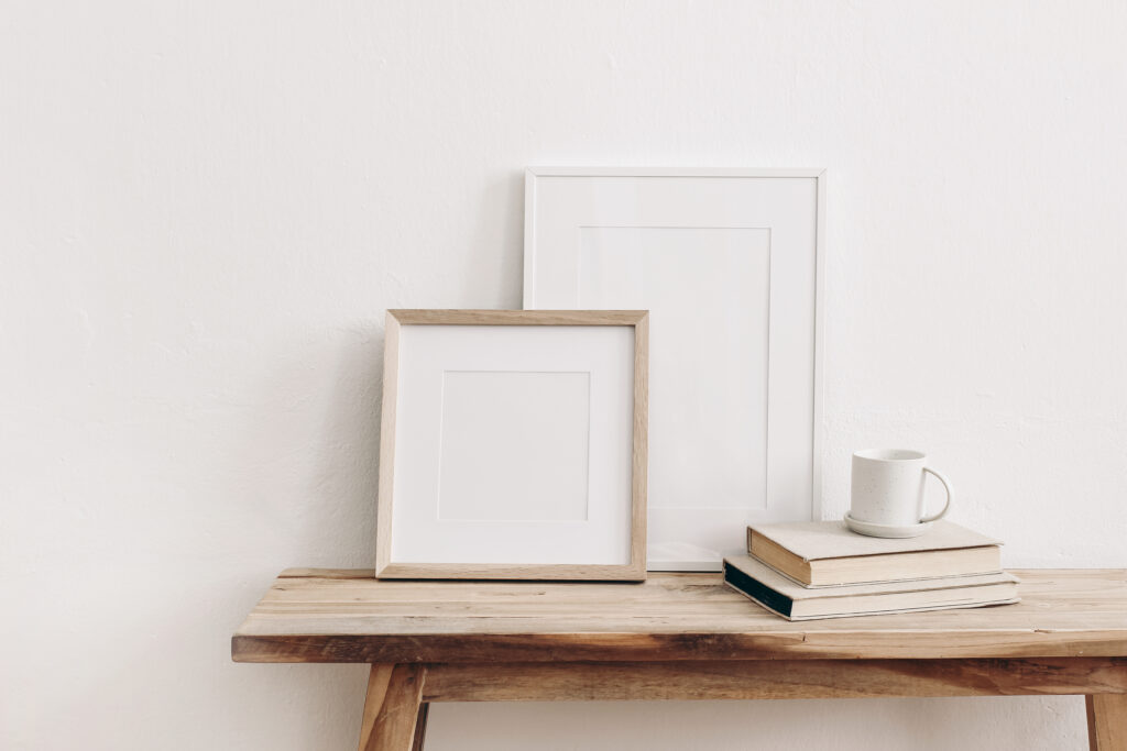 Desk, arranged with photo frames, tea cup and books.