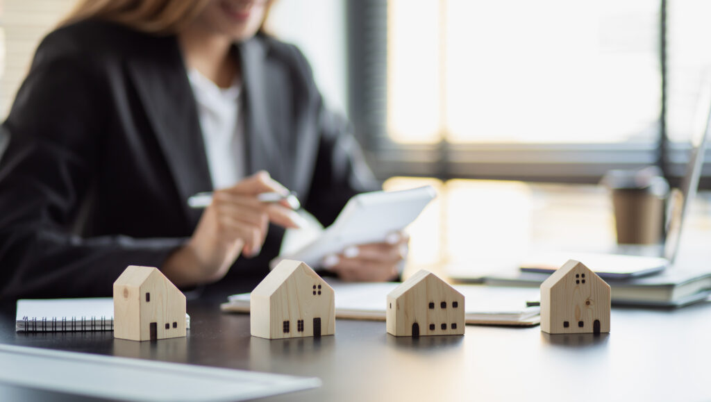 Estate agent on a desk, decorated with little wooden house models. 