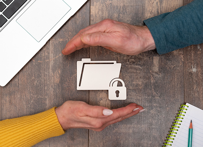 Secured folder icon between man and woman hands.