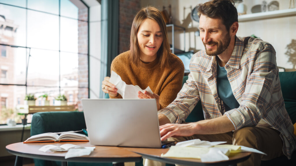 A couple in front of a laptop and discussing income taxes.