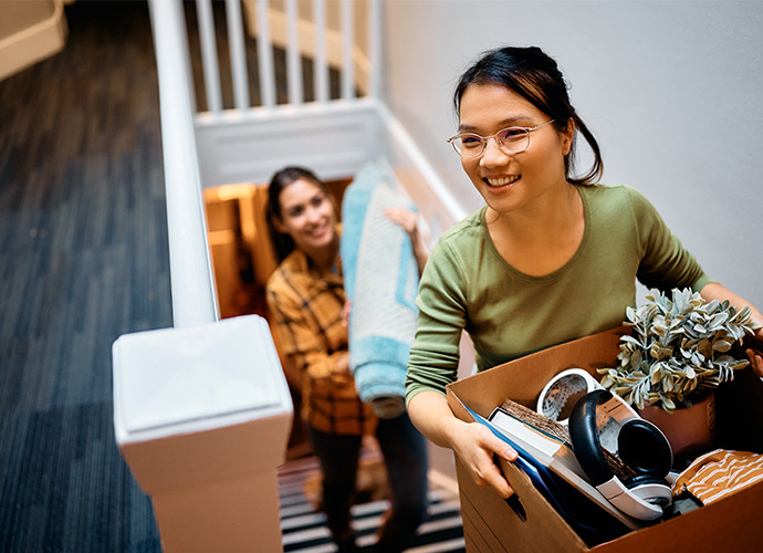 Two woman going upstairs with boxes