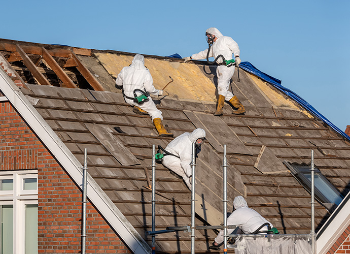 People on a roof removing asbestos