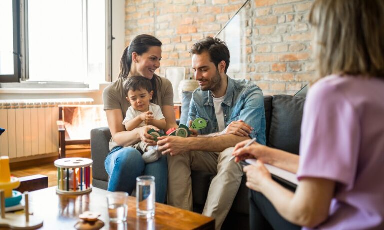 Family with young child discussing a home purchase with an adviser in a UK living room