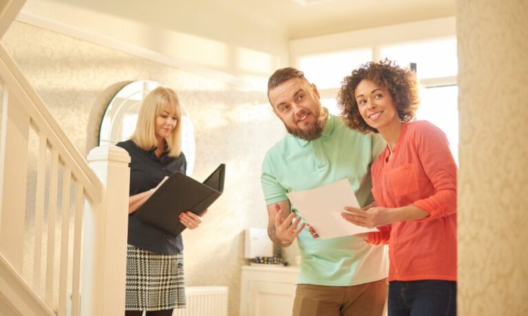 First-time buyers reviewing mortgage paperwork with a property adviser in a UK home