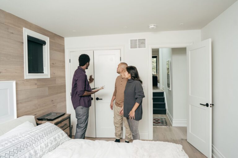 Estate agent conducting a home viewing with buyers inside a modern bedroom in a York village property, reflecting strong buyer confidence following the adoption of the York Local Plan