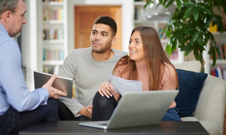 Landlord and tenants reviewing rental paperwork in a living room, representing Bristol rental pricing under 2026 rules