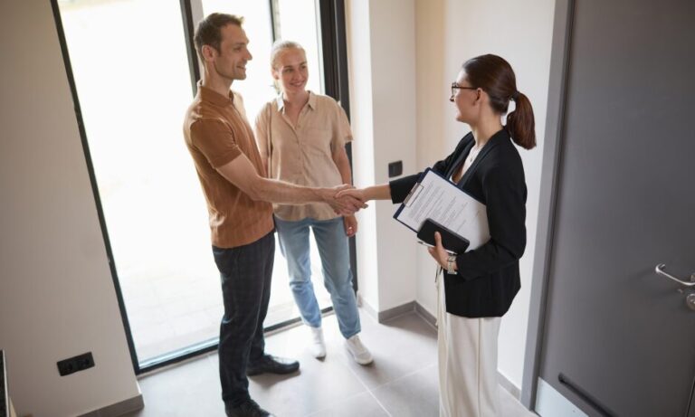 Letting agent shaking hands with landlords during a property meeting related to rental management and compliance in Bristol.