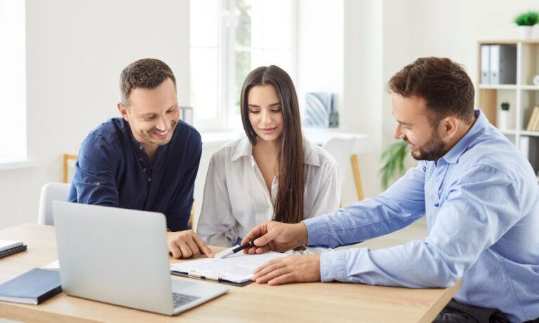 Estate agent reviewing property documents with buyers during a home purchase meeting in St Albans.