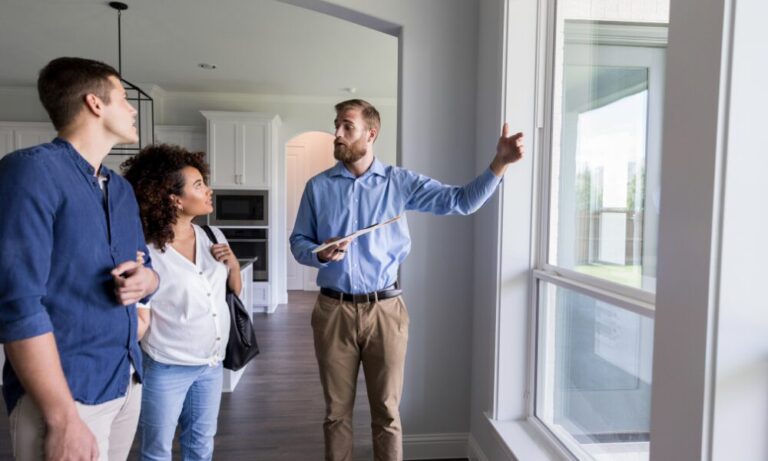 Estate agent showing a property to potential tenants during a viewing related to buy-to-let investment and safety standards in Northampton.