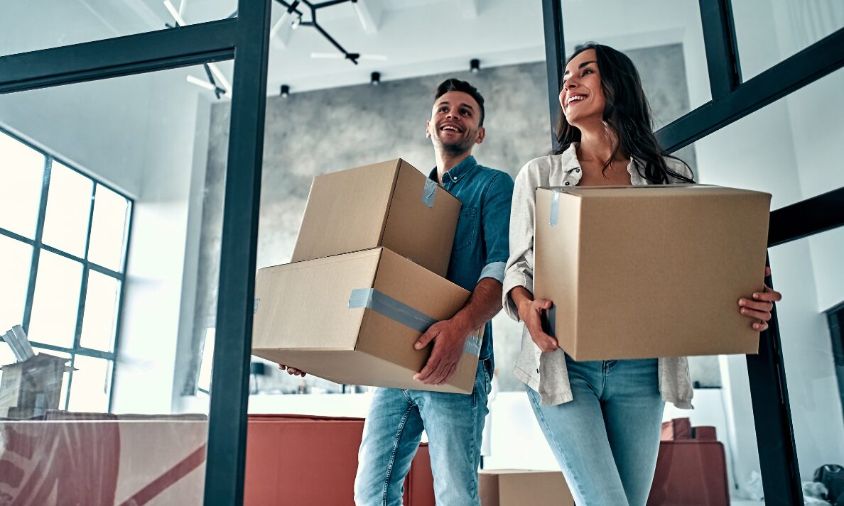 Couple carrying moving boxes into a modern Liverpool rental home in Woolton