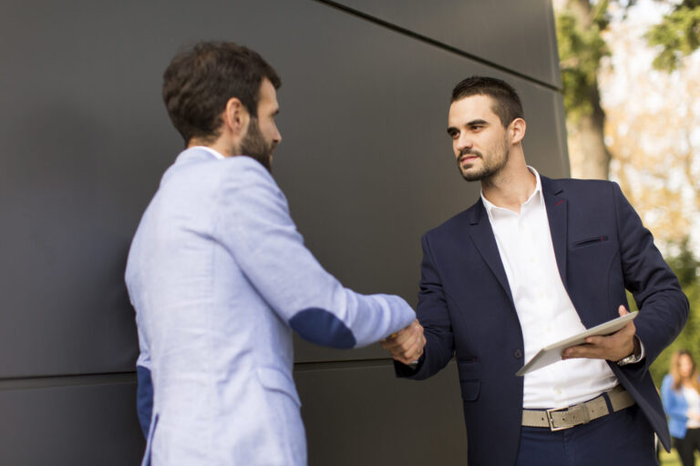 Landlord and letting agent shaking hands while reviewing documents, representing roles, responsibilities and compliance in the UK rental sectorLandlord and letting agent shaking hands while reviewing documents, representing roles, responsibilities and compliance in the UK rental sector