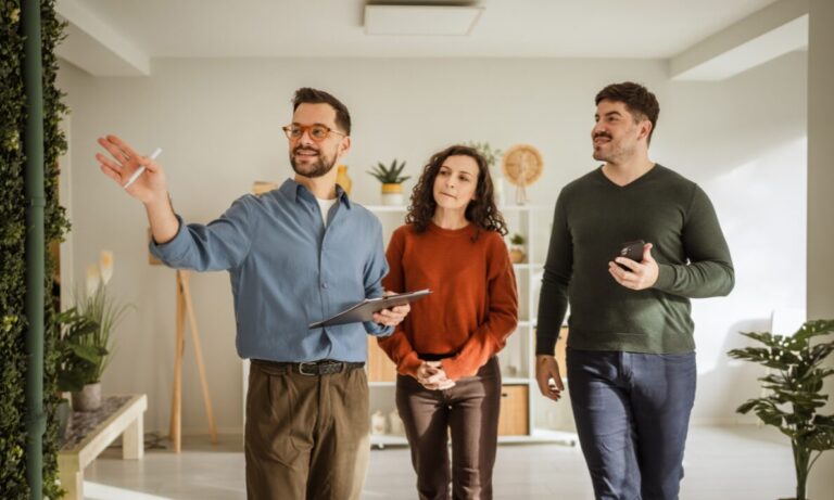 Estate agent guiding a couple through a modern property viewing in Southport