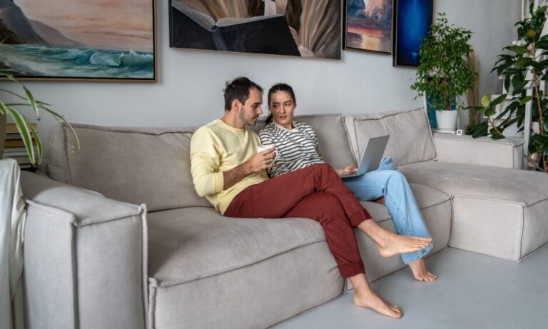 Couple reviewing property information on a laptop at home, representing Liverpool house prices by postcode in 2026.