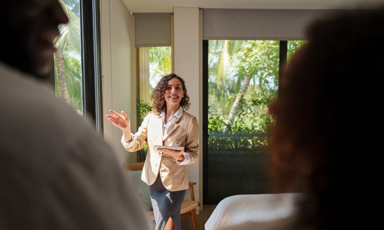 A property agent showing a couple around a bright home, representing buyers and renters exploring property options while living in Warminster BA12.