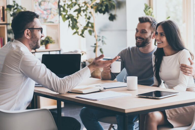 Letting agent discussing property documents with a couple, representing Northampton selective licensing and landlord compliance advice.