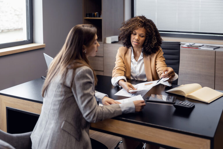 Letting agent discussing property paperwork with a landlord in an office, representing Nottingham landlord compliance under the Renters’ Rights Act.
