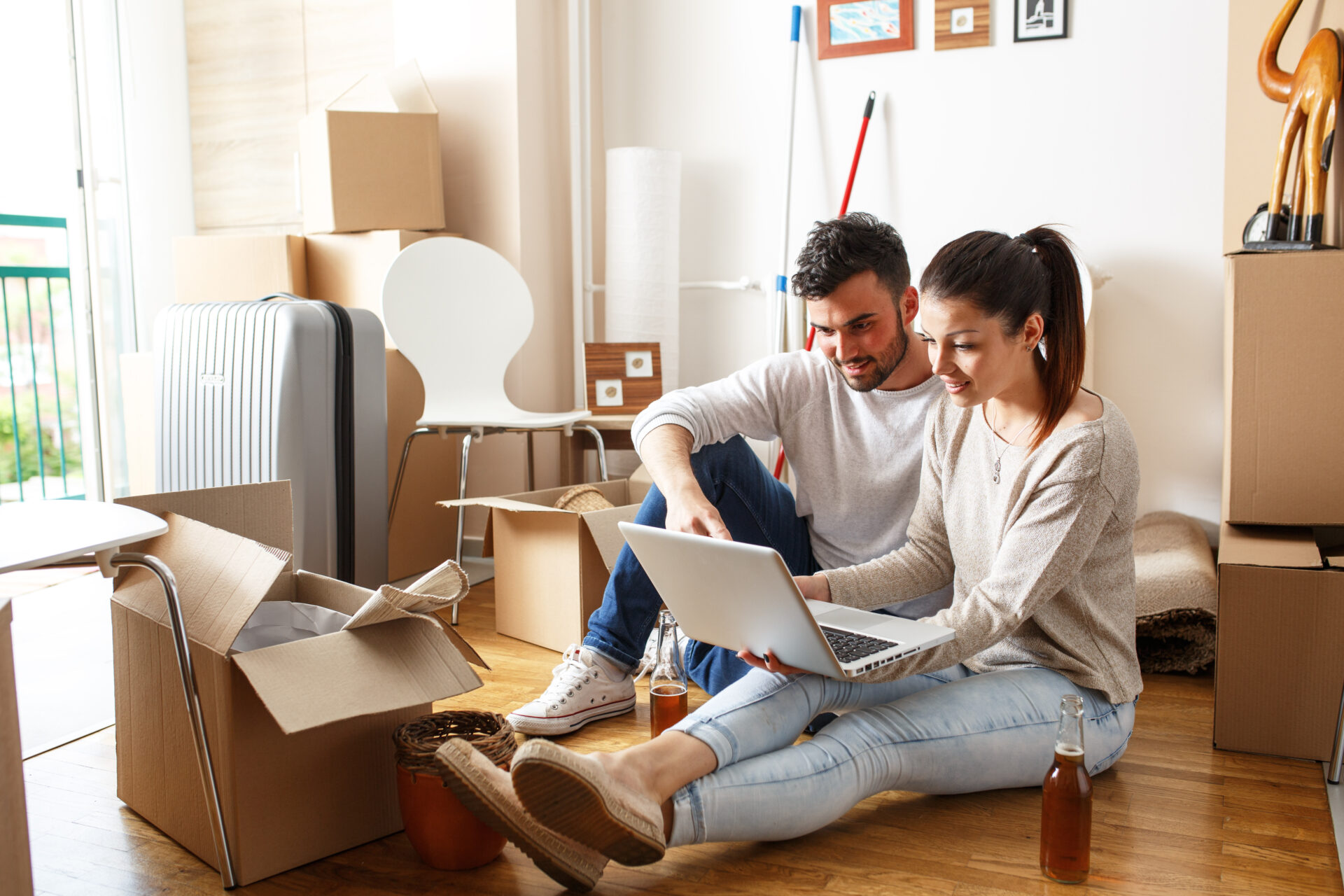 Couple using a laptop while unpacking moving boxes in a rental home, reflecting tenant changes, rental management and landlord responsibilities under the Renters’ Rights Act in York.