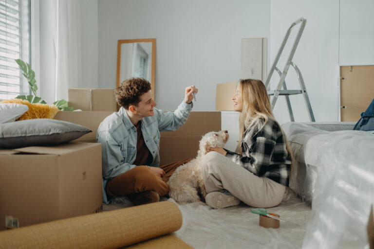 A couple celebrating their new home with their dog after receiving the keys to a property in Westbury BA13.