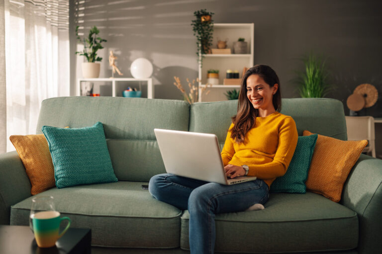 Homeowner using a laptop to research selling a property in Wrexham.