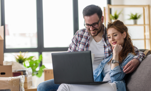 Couple using a laptop while looking for a rental property in Newcastle