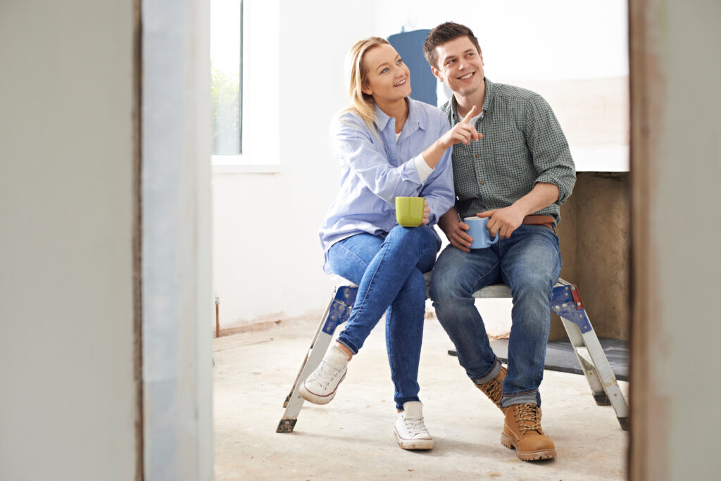 Couple Sitting In Property Being Rennovated